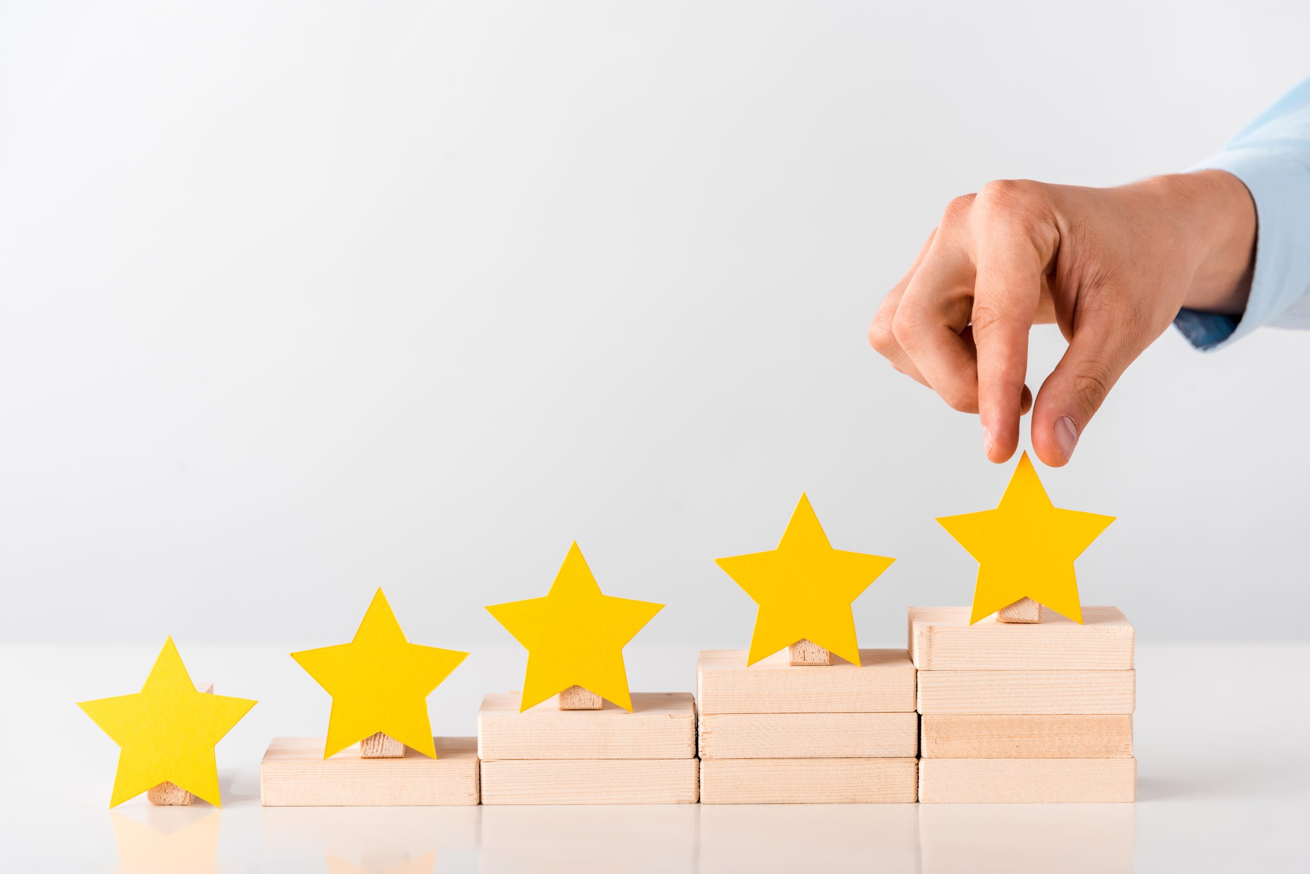 cropped view of man touching yellow star on white man holding review stars